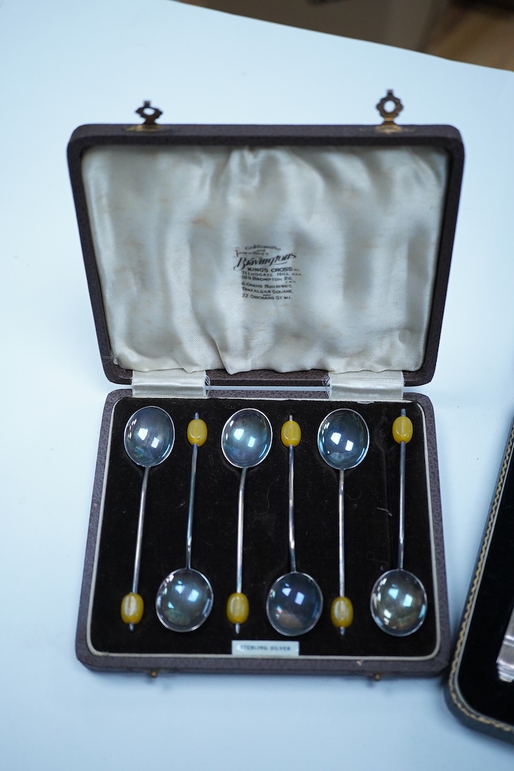 A cased set of six George VI Art Deco silver teaspoons and pair of sugar tongs, by C.W. Fletcher & Son Ltd, Sheffield, 1936, together with a cased set of six silver bean end coffee spoons and a cased set of six plated te